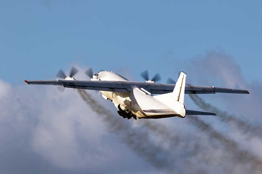 Old cargo airplane taking off with turboprop engine smoke emission